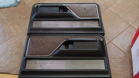 1979 Ford Bronco - Two interior door panels, likely for a truck or SUV, are displayed on a tiled floor.