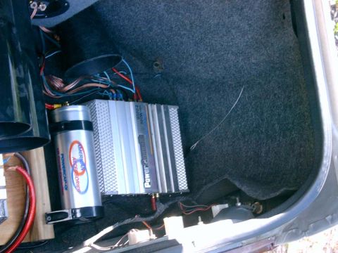 1986 Ford Taurus - Car audio amplifier and capacitor are visible in the trunk of a vehicle.