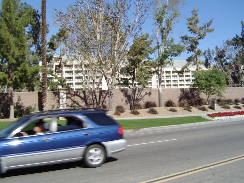 1989 Ford Bronco - A blue and silver station wagon is captured in motion on a sunny day.