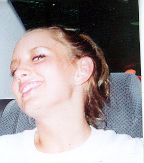 1986 Ford Taurus - A young woman smiles while sitting in a vehicle's passenger seat.