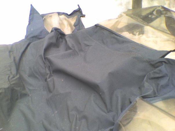Dark blue tarp covers the interior of a 1995 Ford Bronco
