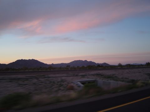 1989 Ford Bronco - A scenic desert view with mountains silhouetted against a pink and blue sky at sunset.