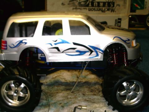 1986 Ford Taurus - This is a remote control monster truck with large tires and blue tribal graphics on the side.
