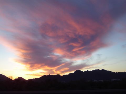1989 Ford Bronco - Sunset clouds paint the sky with vibrant colors over a silhouetted mountain range.