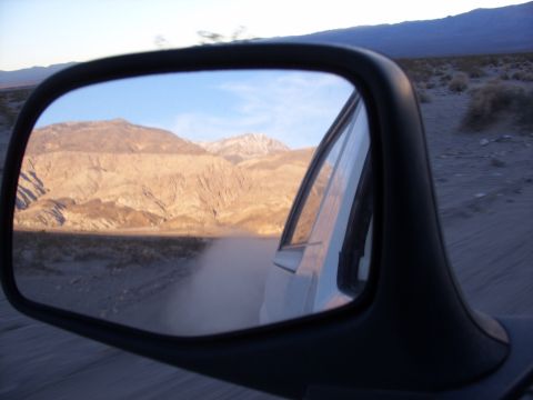1993 Ford Bronco - View of a desert landscape through a side mirror, showing mountains and a dusty road.