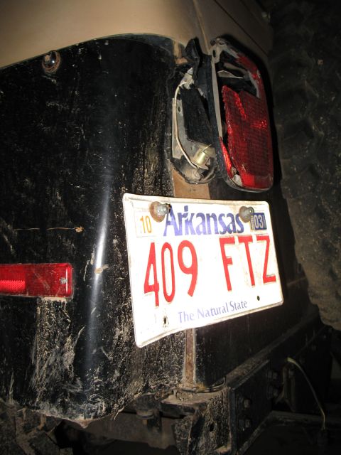 1993 Ford Bronco - The rear of a vehicle shows a damaged taillight and an Arkansas license plate with the number 409 FTZ.