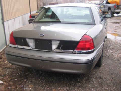 2001 Ford Crown Victoria - Rear view of a tan 2001 Ford Crown Victoria parked outdoors.