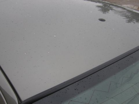 2001 Ford Crown Victoria - Close-up of a car's roof showing water droplets and a dark trim line above the rear window.