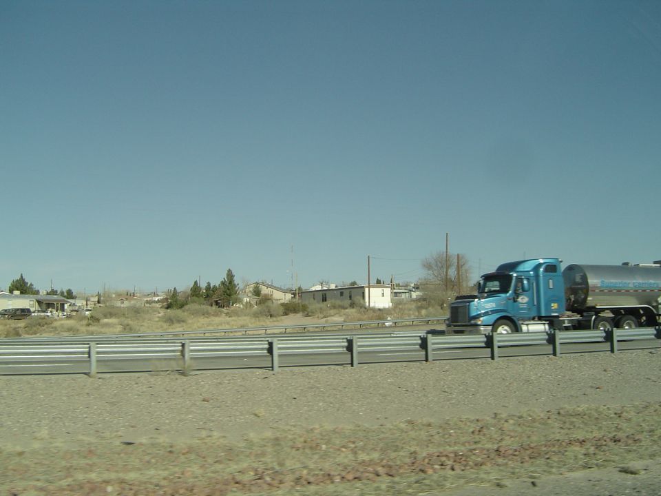 blue semi-truck hauling a silver tanker trailer on a highway