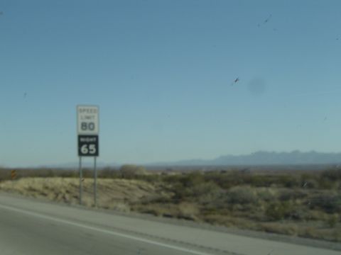 1989 Ford Bronco - A speed limit sign displays 80 and 65 mph on a clear day with a desert landscape in the background.