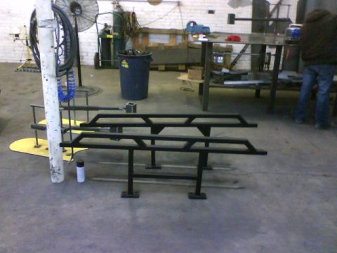 1990 Ford Bronco - These aftermarket rock sliders are for sale in a workshop environment.