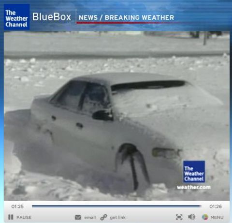 1993 Ford Taurus - A car is stuck and covered in snow, indicating severe winter weather conditions.