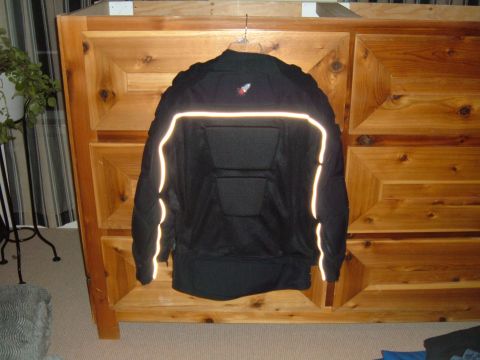 1998 BMW R1100GS ABS - A black motorcycle jacket with reflective piping is displayed on a wooden dresser.