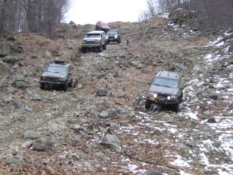 1976 Toyota Land Cruiser - Multiple off-road vehicles navigate a challenging, rocky incline during an outdoor excursion.