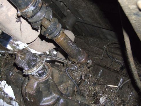 1976 Toyota Land Cruiser - Underside view of a vehicle's driveshaft and differential, covered in mud and debris.