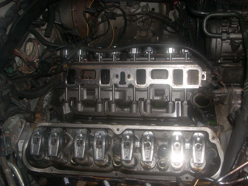 Engine with valve covers off, showing rocker arms and intake manifold
