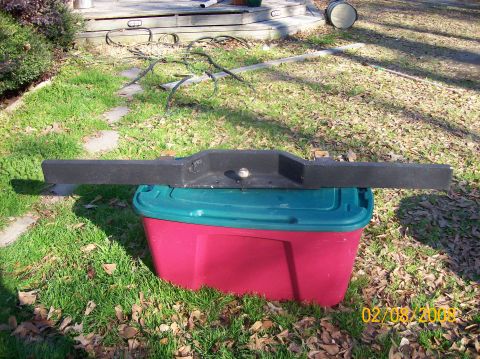 1973 Ford Bronco - A black bumper is shown resting on a red and teal storage bin in a grassy yard.