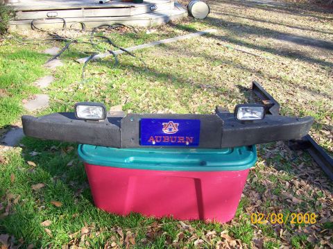1973 Ford Bronco - A bumper with an Auburn logo and fog lights sits on a plastic bin outdoors.