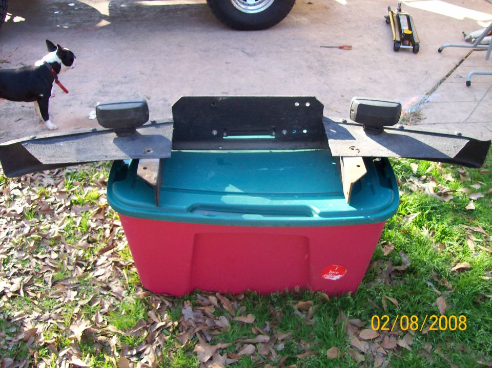 Front bumper with two lights mounted on a red and teal plastic bin