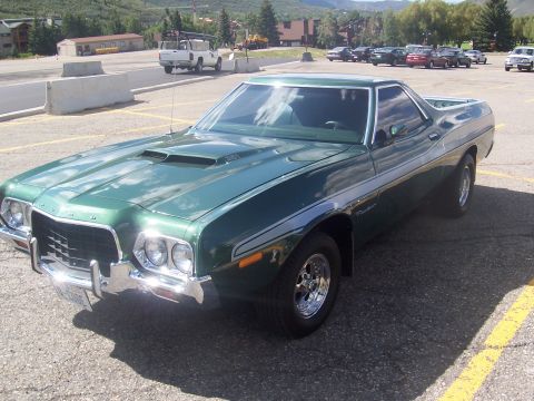 1973 Ford Mustang - A green 1972 Ford Ranchero pickup truck is parked in a lot with mountains in the background.