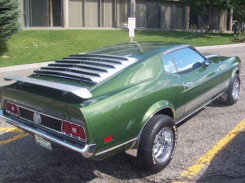 1973 Ford Mustang - This 1971 Ford Mustang Mach 1 features distinctive rear window louvers and a rear spoiler, viewed from the 3q-front angle.
