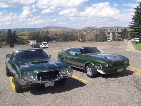 1972 Ford Ranchero - A 1971 Ford Mustang Mach 1 and a 1972 Ford Ranchero are parked side-by-side in a lot with mountains in the background.