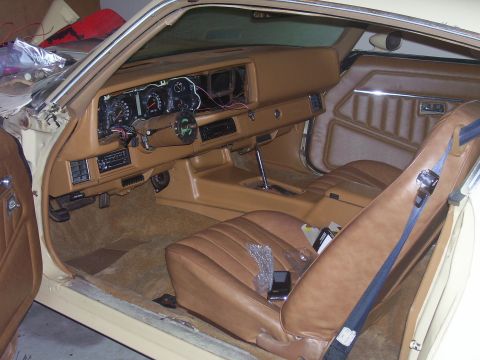 1979 Chevrolet Camaro - The interior of a car shows a disassembled dashboard and tan upholstery.