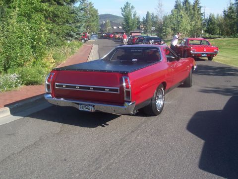 1973 Ford Mustang - A red Ford Ranchero is parked on a street with other vehicles in the background.
