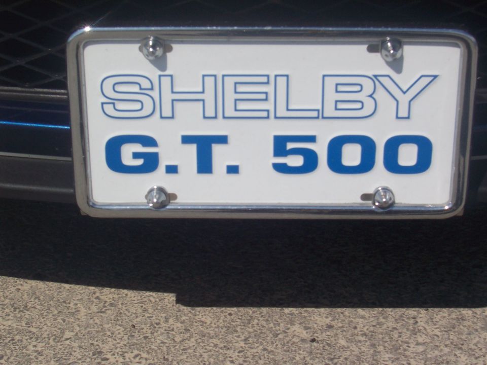 License plate frame with blue text 'SHELBY G.T. 500' on white background