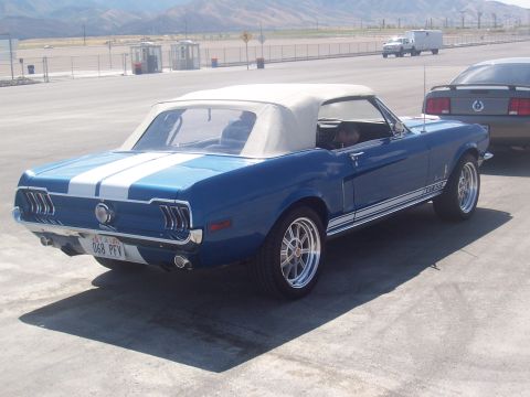 1973 Ford Mustang - Blue convertible classic car with white racing stripes is parked outdoors.