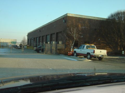 1992 Ford Bronco - A white pickup truck with a snow plow is parked outside a commercial building on a clear day.