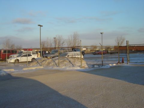 1992 Ford Bronco - A winter scene shows several vehicles parked in a lot, partially covered in snow.