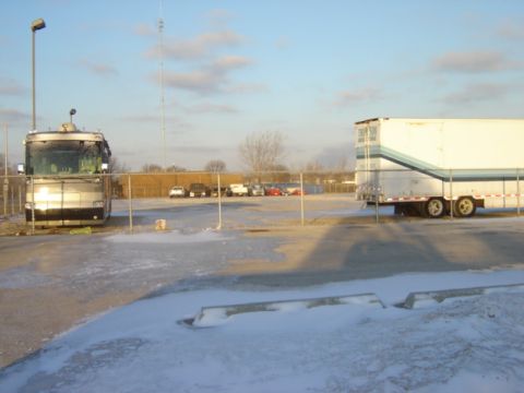 1992 Ford Bronco - Motorcoach and trailer parked in a lot with snow on the ground and a radio tower in the distance.