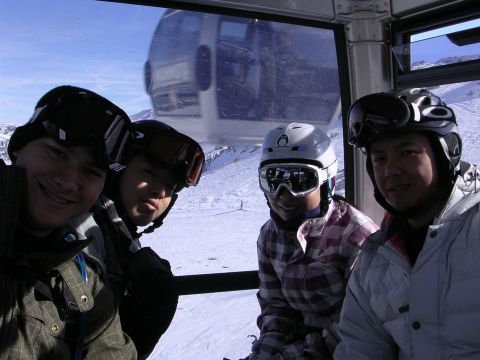 1983 Ferrari Enzo - A group of friends enjoys a scenic ride in a ski gondola, surrounded by snow-covered mountains.