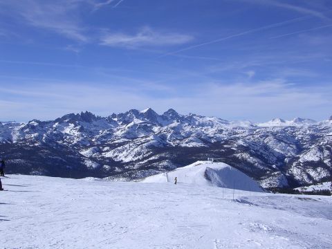 1983 Ferrari Enzo - A vast, snow-covered mountain range under a bright blue sky, with ski slopes and distant skiers.