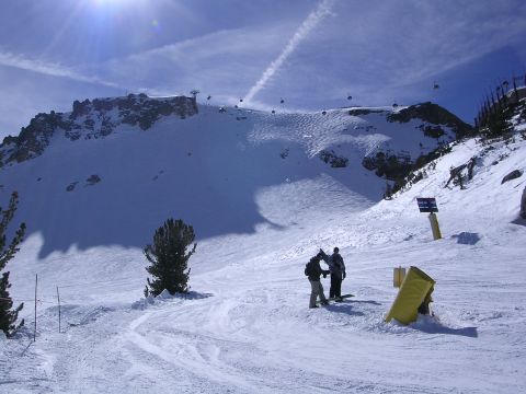 1983 Ferrari Enzo - A scenic view of a ski resort, gondolas traversing the sky above skiers on a snowy mountainside.