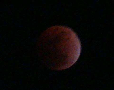 1989 Ford Bronco - A view of the moon during an eclipse, appearing red against the blackness of space.