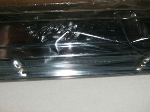 1995 Ford Probe - A close-up of a chrome trim piece, likely a car emblem, is shown wrapped in protective plastic.