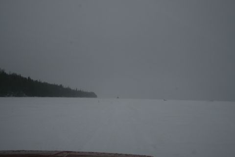 2003 Jeep TJ - Wide view of a snow-covered area with a treeline and faint figures in the distance.