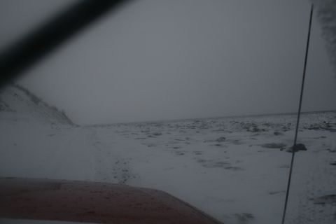 2003 Jeep TJ - View from inside a vehicle driving through a snow-covered landscape under an overcast sky.