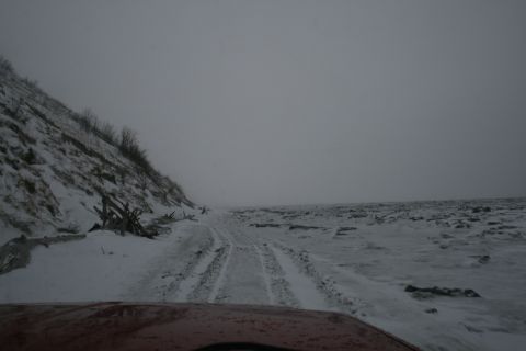 2003 Jeep TJ - Driving through a snowy and icy landscape with debris scattered along the roadside.