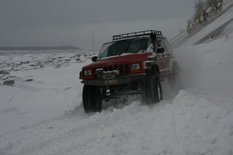 2003 Jeep TJ - Jeep Cherokee XJ navigates a snowy landscape with a winch and roof rack.