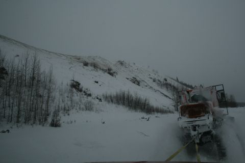 2003 Jeep TJ - A snow plow operates in a snowy, barren landscape under an overcast sky.