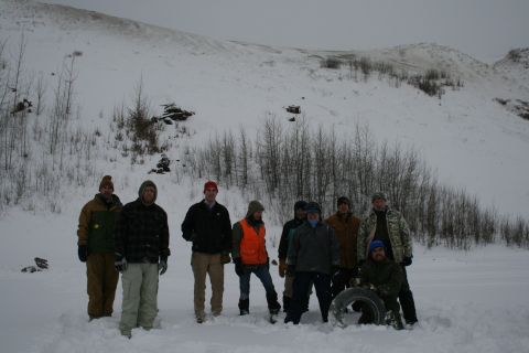2003 Jeep TJ - A group of people stand in a snowy landscape with a tire visible.