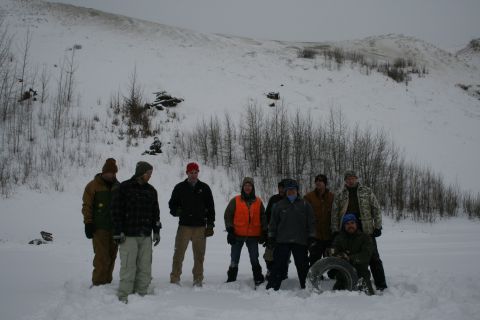 2003 Jeep TJ - A group of people stand in a snowy landscape, with a single tire visible in the foreground.