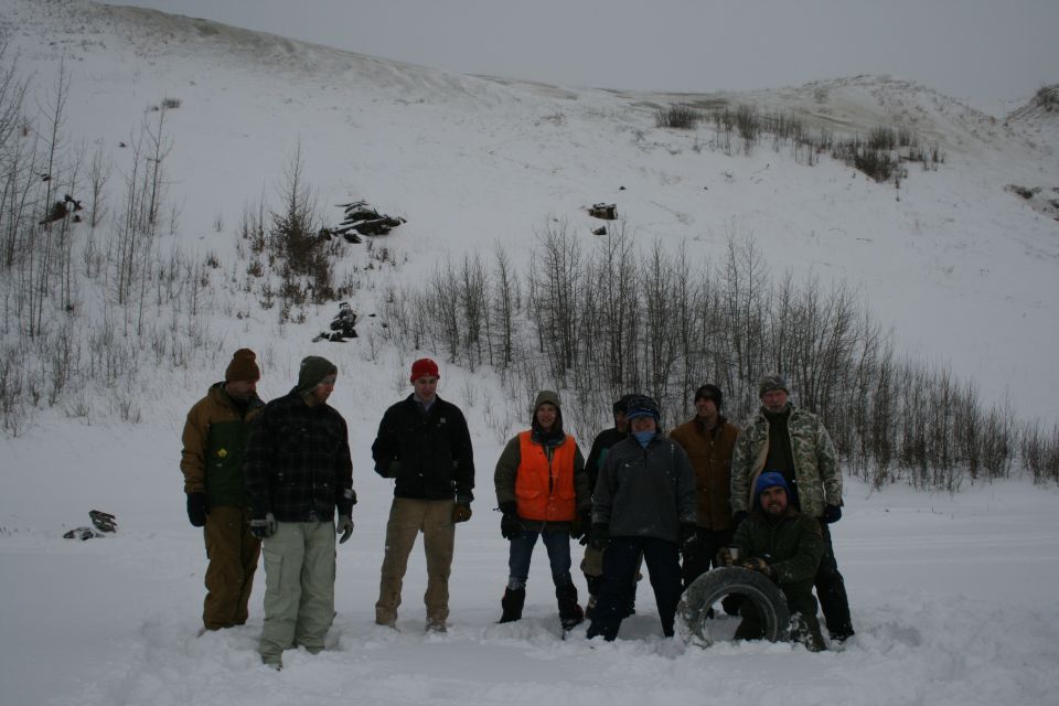 Group of people in snow with a tire, winter scene
