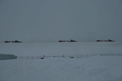 2003 Jeep TJ - Industrial equipment is visible in the distance on a snowy landscape.