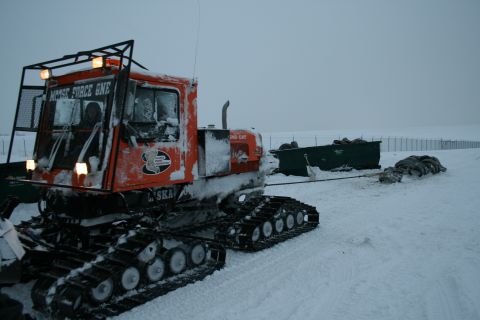2003 Jeep TJ - Snowcat vehicle operating in a snowy environment, towing a large container.