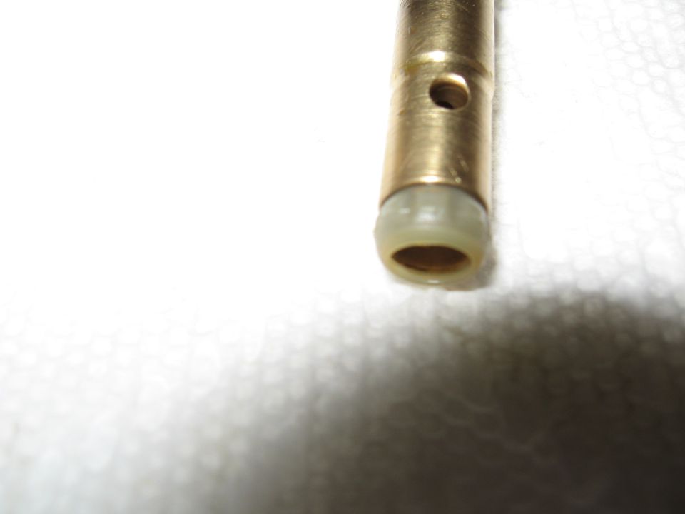 Close-up of a brass proportioning valve with a beige plastic seal