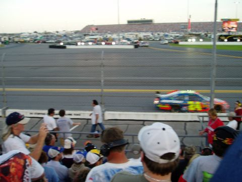 2000 Ford E350 - A race car speeds around the track as spectators watch from the stands.